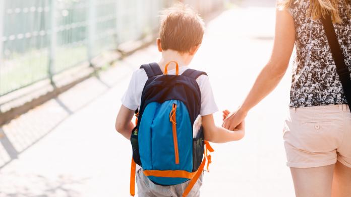 7 years old boy going to school with his mother
