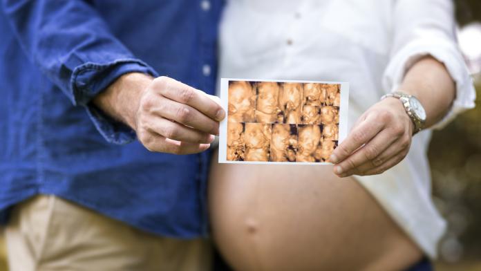 belly of a pregnant woman with father
