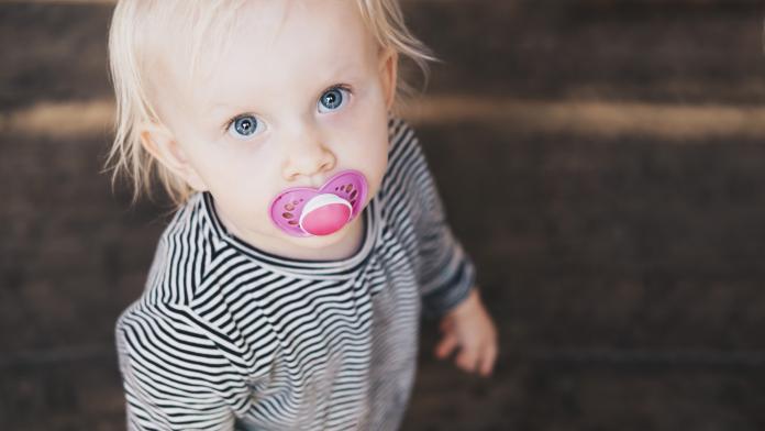 High angle view of girl with pacifier standing outdoors