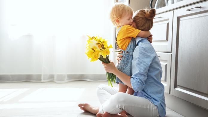 happy mother's day! baby son gives flowersfor mother on holiday