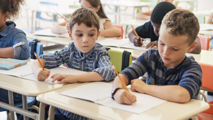 Elementary students taking a test in classroom.