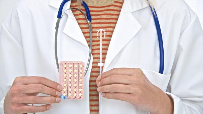 Doctor holding intra uterine device and p
