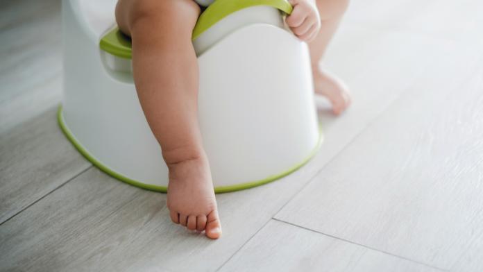 Close up of a toddler sitting on a potty chair on potty training
