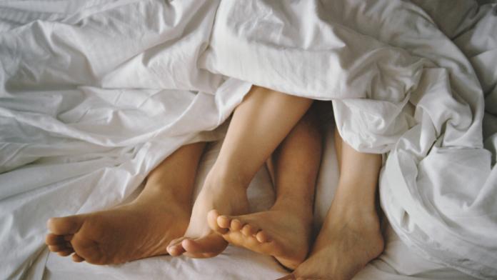 Couple's Feet Entangled in Bed
