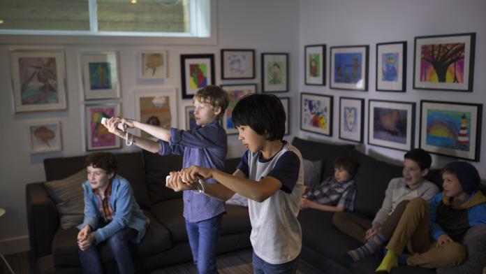 Boys playing video game in living room