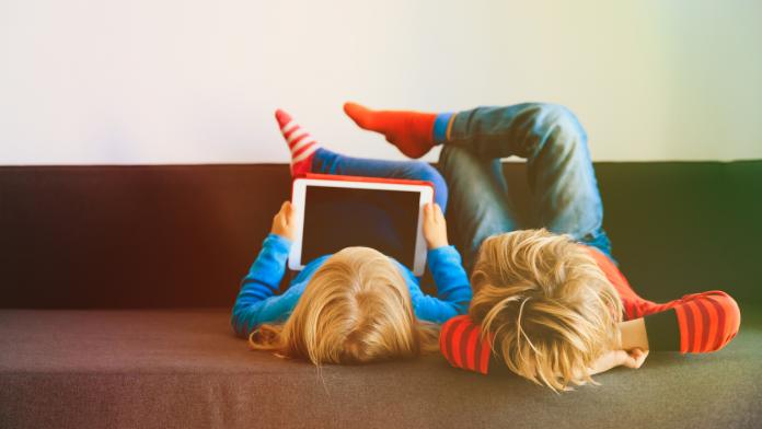 little boy and girl looking at touch pad at home