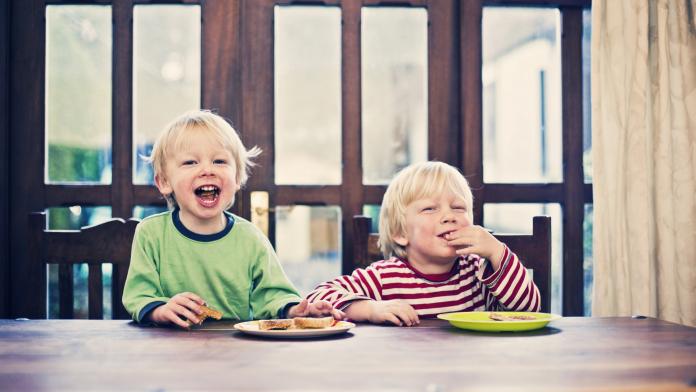 Two little boys eating toast for breakfast
