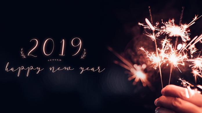 Hand holding burning Sparkler blast with happy new year 2019 on a black bokeh background at night,holiday celebration event party,dark vintage tone.