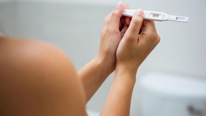 Woman holding a pregnancy test