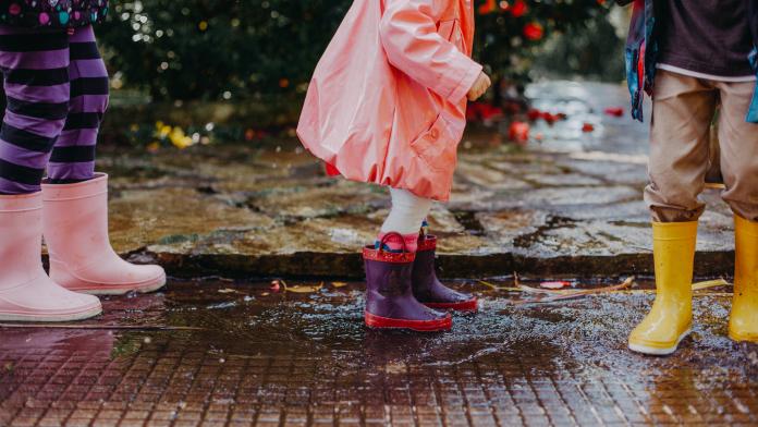 kids with rain boots in a row regenlaarzen