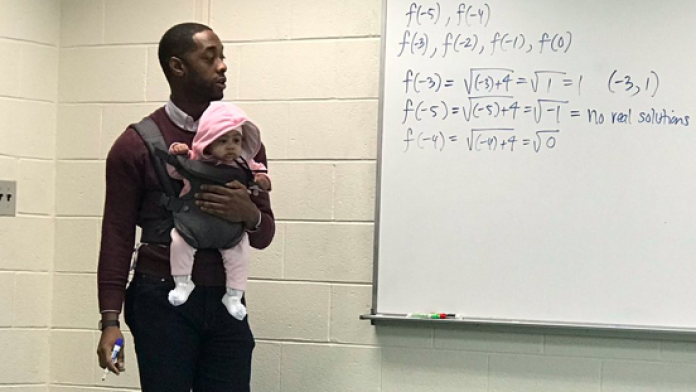 Un professeur enseigne avec un bébé dans les bras pour une bonne raison