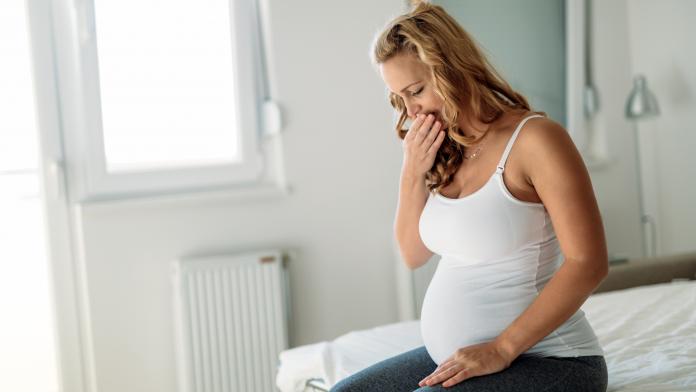 Portrait of blonde pregnant woman feeling sick
