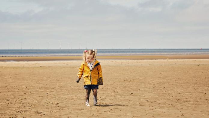 Child walking on the beach zomerjas meisje
