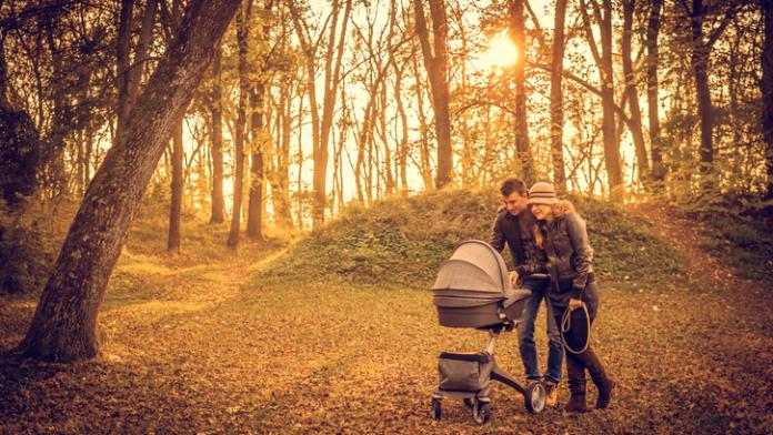Happy family in the park on autumn day kinderwagen