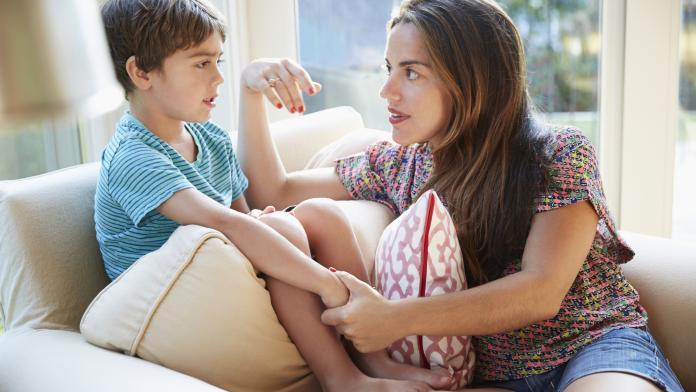 Mother talking to son on the sofa