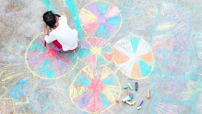 Young kid playing with chalk. Blijf in uw kot activiteiten kinderen