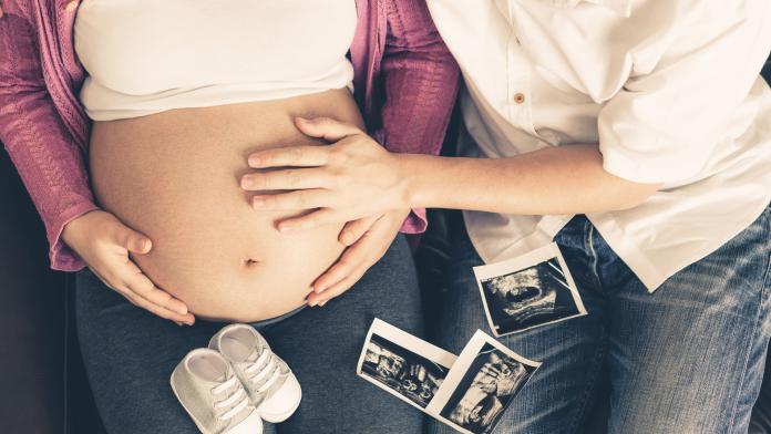 Pregnant couple feels love and relax at home. zwangerschap papa band baby