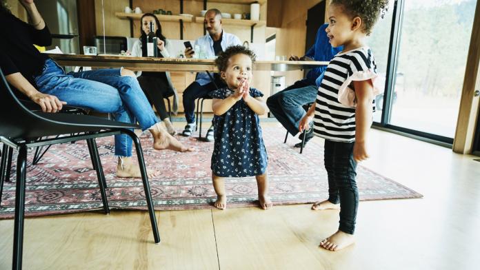 Young sisters playing during multigenerational family meal