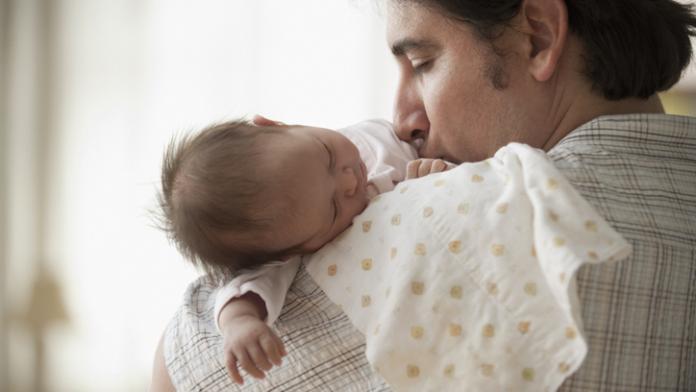 Hispanic father holding newborn baby girl