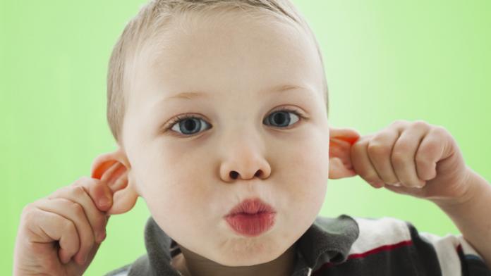 Caucasian boy pulling his ears flaporen