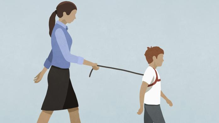 Mother walking son with harness