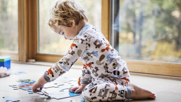 Baby boy playing jigsaw puzzle at home