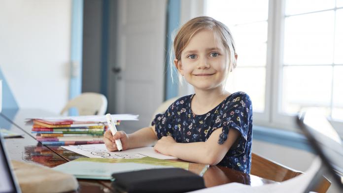 Portrait confident girl doing homework at dining table Steenbok