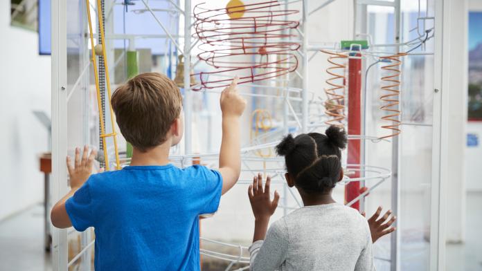 Two kids looking at a science exhibit, back view krokusvakantie tips kinderen