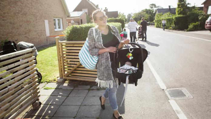 Mother carrying son (0-1 months) in portable car seat