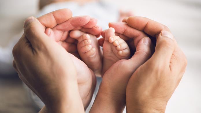 Little baby feet in parents hands geboren in lockdown