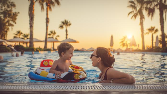 Child with mother in swimming pool, holiday resort