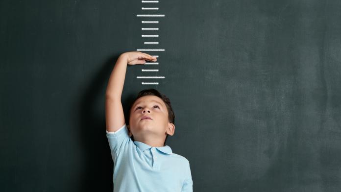 Child measuring his height on wall. He is growing up so fast. diy groeimeter kinderkamer