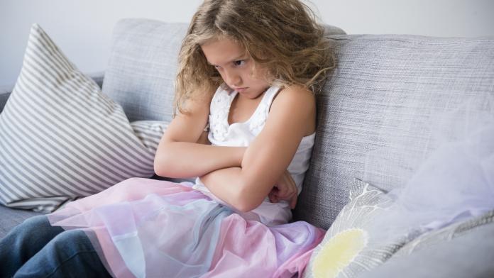 Frustrated girl wearing tutu pouting on sofa prepuberteit, puberteit ontwikkeling
