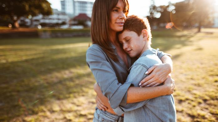 teenager embraced with mom consoling her son knuffelen kind puber