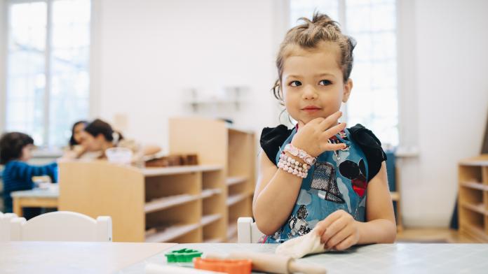 Girl playing with toys at table in child care classroom Koalatoets