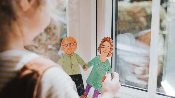 Little girl holding cut-out paper People pleegouder worden