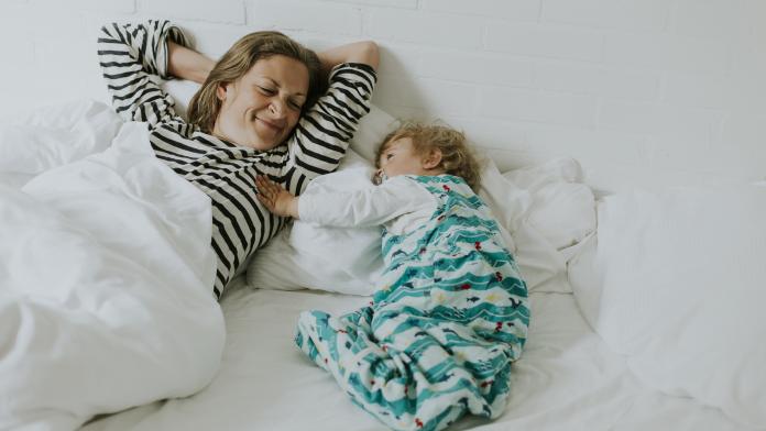 Mother and little daughter in bed slapen slaapzak winter