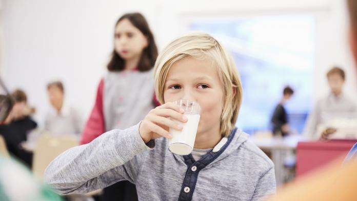 Boy drinking milk during lunch break in school cafeteria plantaardige dranken plantaardige voeding gezonde voeding school