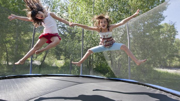 Sisters jumping on a trampoline Veilig trampolinespringen