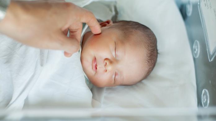 Newborn baby boy asleep in hospital bassinet Spaanse babynamen, babynamen, inspiratie