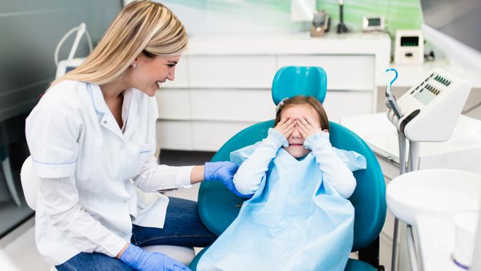 Girl at dentist office bang voor de tandarts kind angst voorbereiding