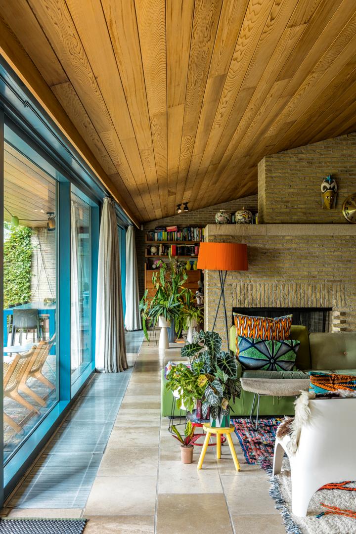 De woonkamer spreidt zich uit over de hele achterzijde van de woning en bestaat uit een open ruimte en een knusse hoek aan de openhaard.