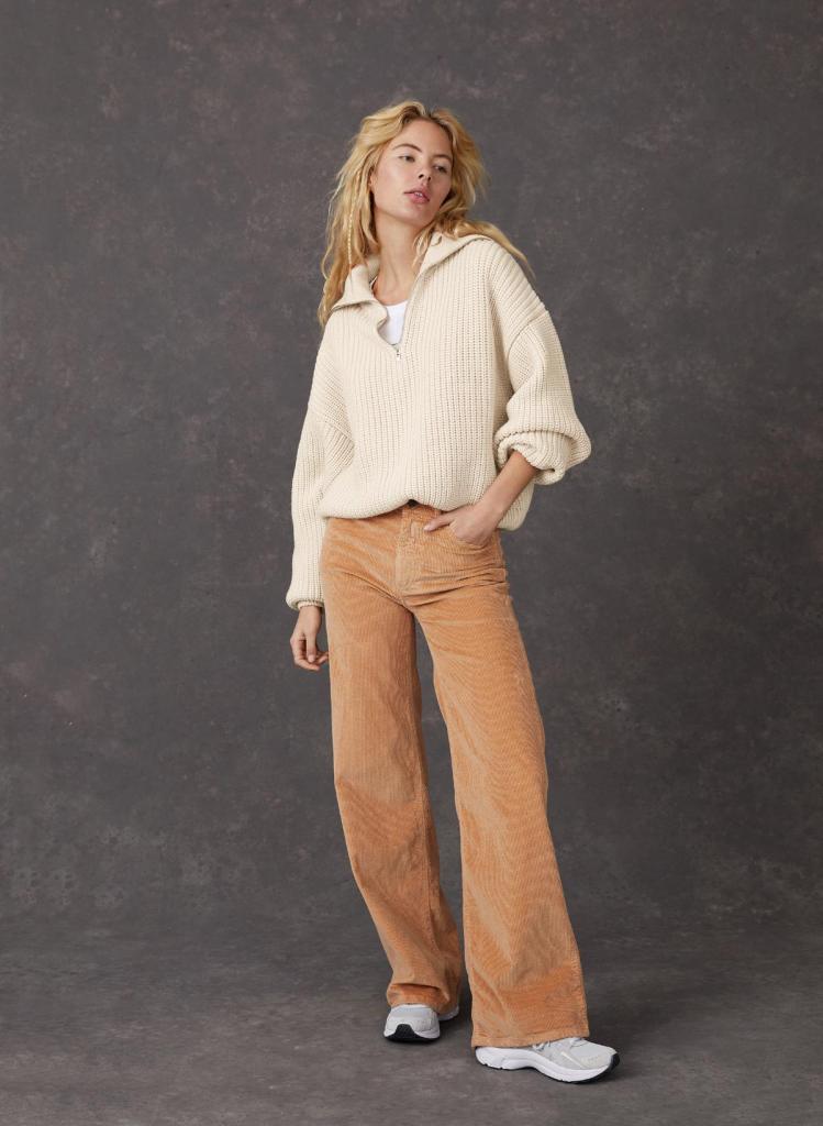 Wijde ribfluwelen pantalon in seventies stijl (109,95 euro) en sweater met rits in biokatoen (129,95 euro), van Lois.