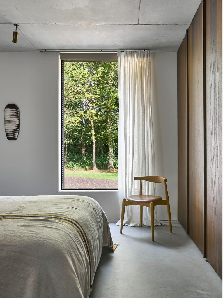 In de slaapkamer prijkt een Elbow Chair van Carl Hansen & Søn, aan de muur een van de zeldzame kunstwerken die in het interieur hangen.