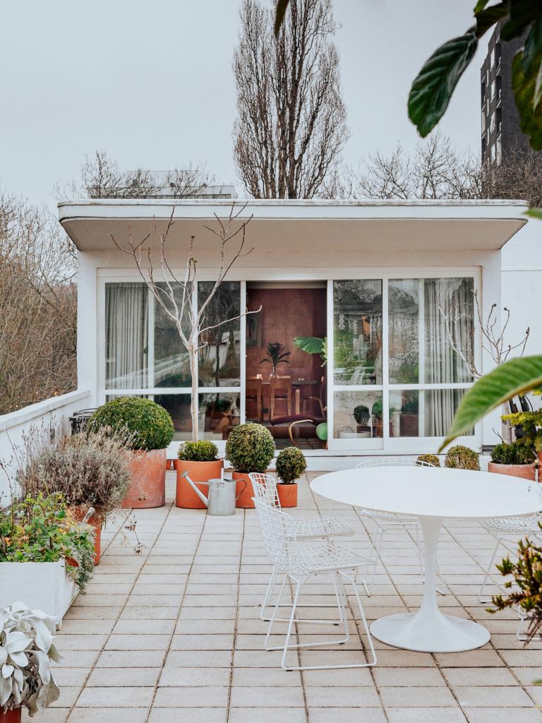 Op het terras van honderd vierkante meter staan een tafel van Eero Saarinen voor Knoll met stoelen van Harry Bertoia.