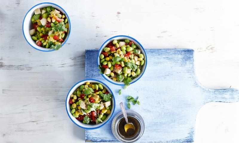 A fresh salad with edamame and diced vegetables.