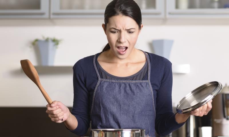 Young housewife having a calamity in the kitchen reacting in shock and horror as she lifts the lid on the saucepan on the stove to view the contents as she cooks dinner; Shutterstock ID 238713445; Projectnummer: B09773; Uitgave: www.libelle-lekker.be; Traffic: Sofie Doms; Anders: .