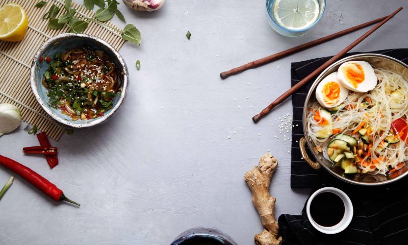 Spicy veggie wok: rice noodles with zucchini, onion and carrot. Asian styled lunch on rustic background. Composition with copy space for text; Shutterstock ID 685823050; Projectnummer: B09773 ; Uitgave: Libelle Lekker; Traffic: Rien Delvaux; Anders: /