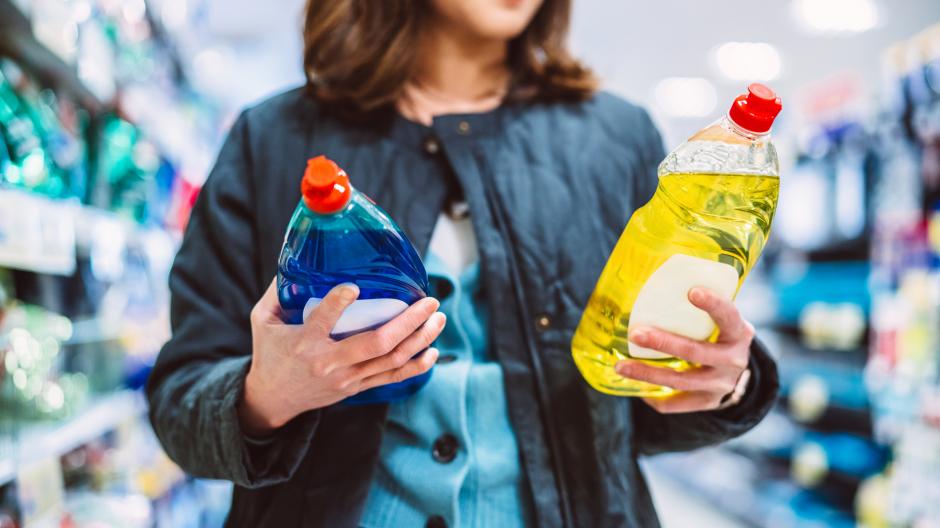 Een vrouw die de prijs van producten vergelijkt in de winkel. Kortingen tips.