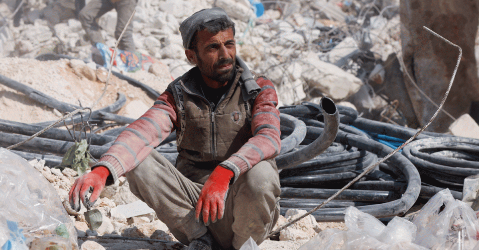 Man zit op puin na ravage aardbeving Harem, Syrië